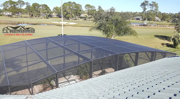 Dome-style pool cage in Ormond Beach seen from the roof, with a golf course behind it