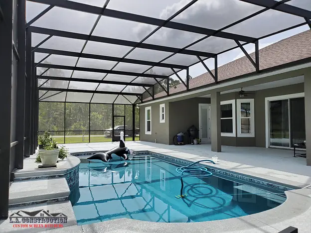 Inside a dome-style pool screen enclosure: pool, covered patio and an inflatable orca float