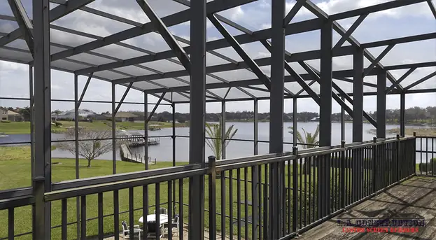 Second-floor deck inside a two-story dome-style pool enclosure in Clermont, looking out over a lake