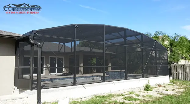 Dome-style pool screen enclosure with bronze frame and kick plate on a home in Edgewater, FL
