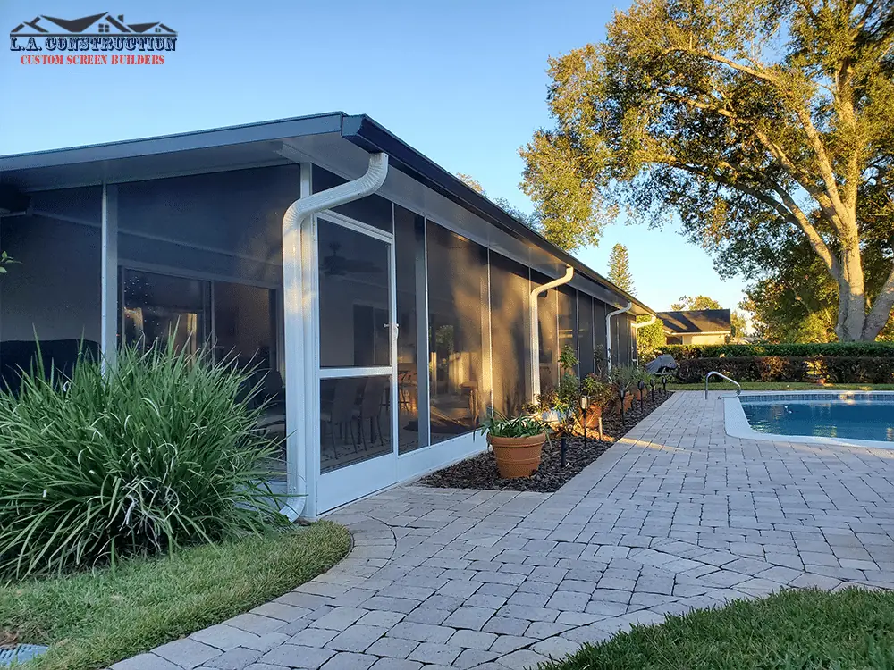 White screen room with a kick plate along a home in Maitland, FL, beside the pool